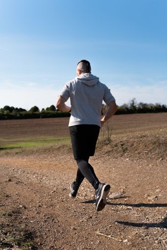 A vertical shot of an athlete running and working out on a warm sunny day