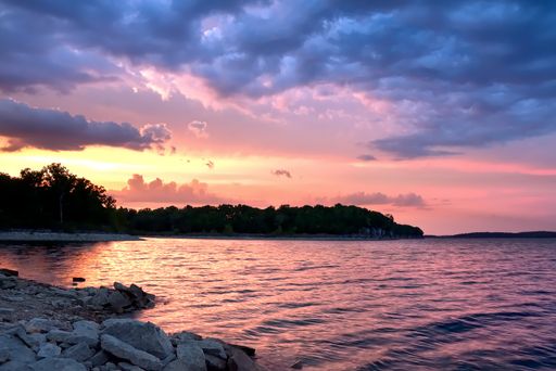 A beautiful scenery of the sunset reflecting in the sea under the breathtaking colorful clouds