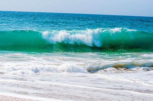 A beautiful shot of calming and splashing ocean waves on a sunny day