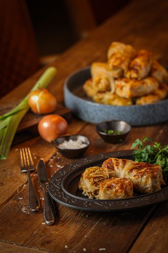 A vertical shot of stuffed cabbage rolls served on a black plate