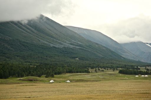 A beautiful landscape surrounded by mountains gleaming under the cloudy sky