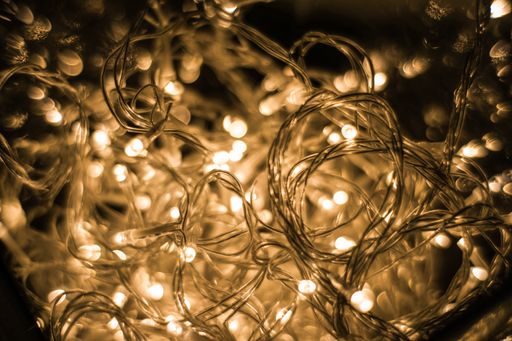 A closeup shot of illuminated string lights on a black background