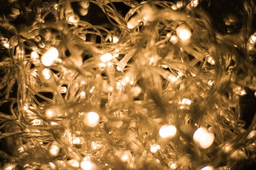 A closeup shot of illuminated string lights on a black background