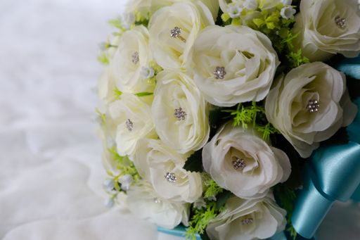 A closeup shot of a rose bridal bouquet on a bed