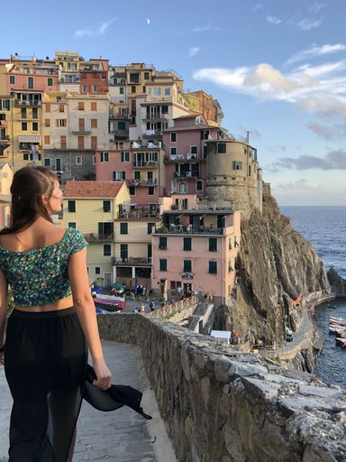 girl during a summer walk discovers Manarola, the typical town of the Cinque Terre