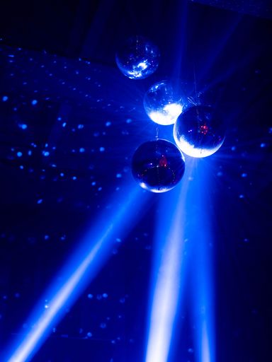 A vertical shot of disco balls and blue neon lights at the club