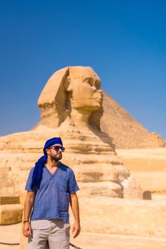 A young tourist wearing a blue turban standing near the Great Sphinx of Giza, Cairo, Egypt