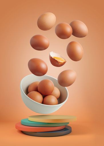 Brown eggs in the air on a brown background.