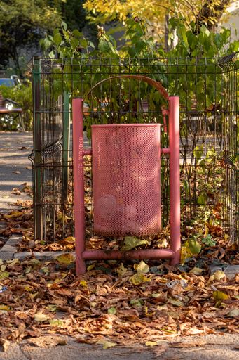 A vertical shot of a recycle bin on autumn park