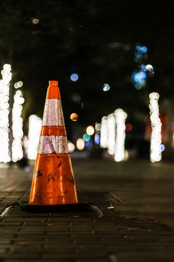 A vertical shot of road cone at night