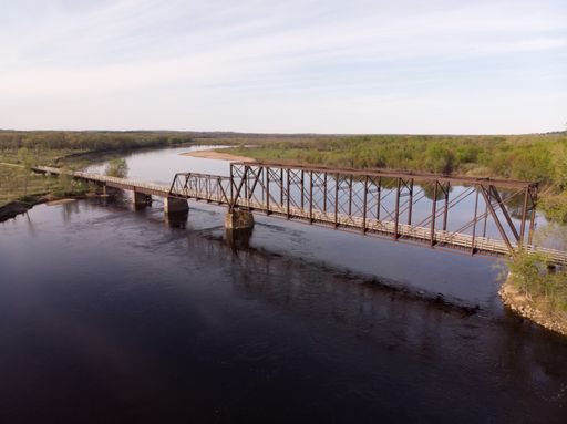 A high angle shot of a bridge over a wide river