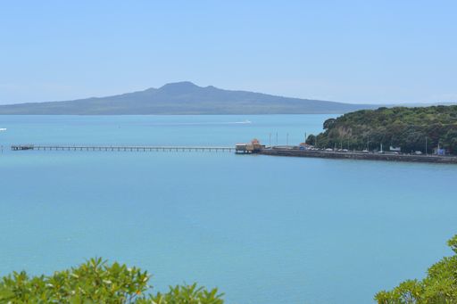 View of Okahu Bay Wharf and Sea View Bridge at Tamaki Drive with Rangitoto dormant volcano island in background