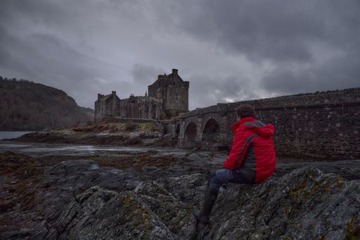 HIstoric castle and famous for its proximity to the Iska de Skye. Cold environment at low tide.man in scene