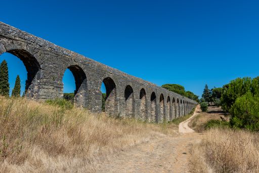The Roman aqueduct of Pegoes surrounded by greenery under sunlight in Tomar in Portugal