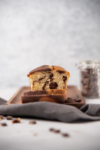 A vertical shot of a delicious chocolate sponge pie slices on a wooden board on the table