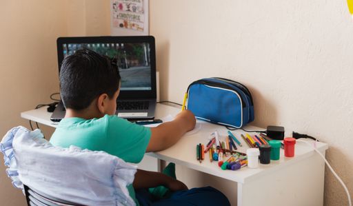 A high angle shot of a child receiving virtual classes from home