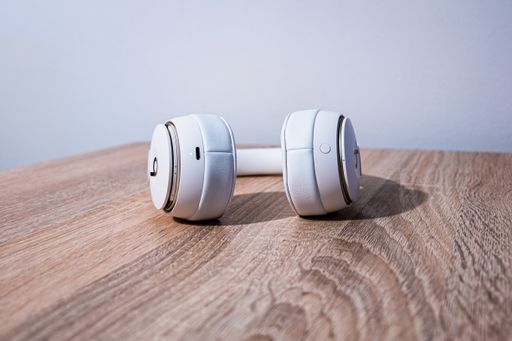 A closeup shot of Beats headphones on a wooden surface with a clear white background