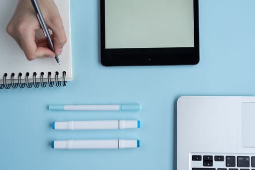 A top view of a student's desk with a phone, a notepad, and other studying supplies