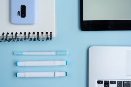 A top view of a student's desk with a phone, a notepad, and other studying supplies