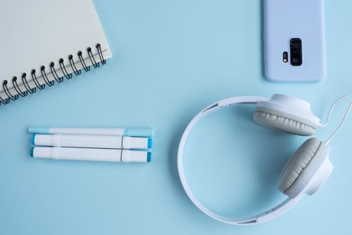 A top view of a student's desk with a phone, a notepad, and other studying supplies