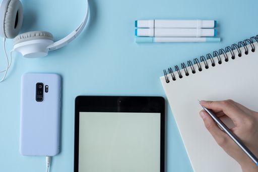 A top view of a student's desk with a phone, a notepad, and other studying supplies