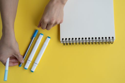 A top view of a desk with markers and a notepad