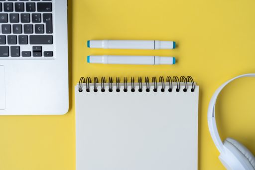 A top view of a student's desk with a laptop, a notepad, and other studying supplies
