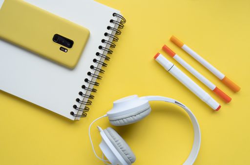 A top view of a student's desk with a phone, a notepad, and other studying supplies