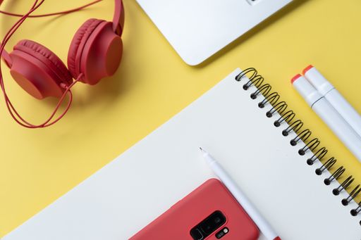 A closeup shot of a students desk with a notepad and headphones