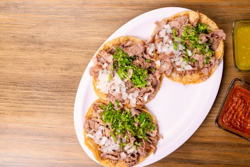 A top view of a traditional appetizing Mexican food with various sauces served on a wooden table