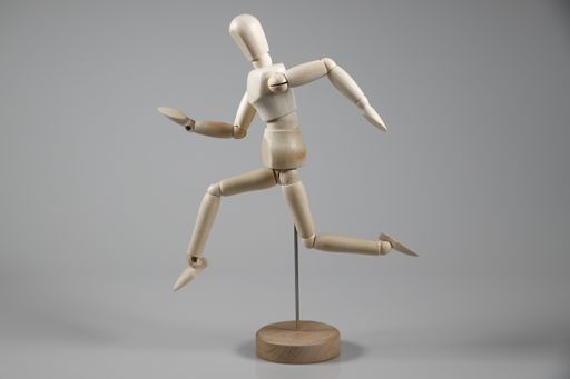A wooden mannequin work out isolated on gray background