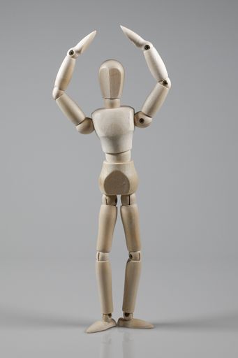 A vertical shot of wooden mannequin isolated on gray background