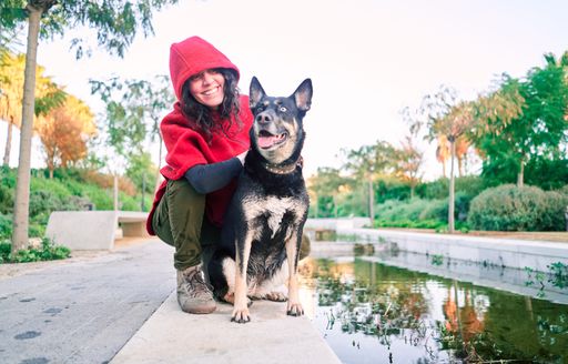 A young Caucasian female playing with her dog in the park