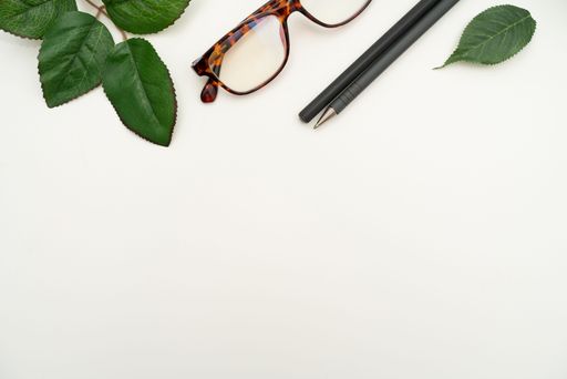 Office Supplies Over Desk With Keyboard And Glasses And Coffee Cup For Working Remotely, Assorted School Utilities With Hot Drink And Eyeglasses.