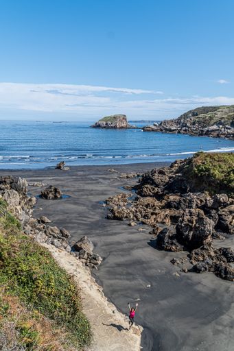 A shot of stones on the shore, the scenic waterscape of the Bay of Biscay in the background