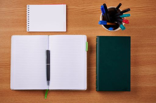 Plain Blank Open Notebooks With Stack Of Pens Inside Container On Top Of Table. Simple Empty Lined Notepads Beside Holder Of Ballpens On Desk.