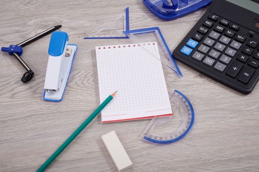 Blank Notebook Page With A Calculator And Geometric Stationery. Empty Lined Notepad With Calculation Compass Office Supplies Over Desk.