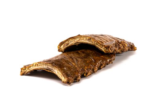 A close-up of two grilled ribs together on a white background