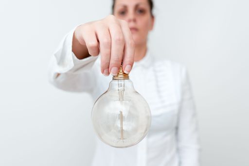 Lady holding lamp upside down in Shirt presenting new ideas for project Business woman carrying bulb opposite showing late technologies