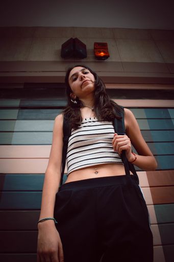 A low angle shot of a girl posing on the street