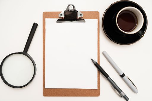 Office Supplies Over Desk With Keyboard And Glasses And Coffee Cup For Working Remotely, Assorted School Utilities With Hot Drink And Eyeglasses.