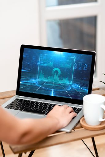 Hand On Laptop Top Of Table Beside Coffee Mug Actively Accomplishing Work From Home. Arm Making Tasks Next To Cup Finishing Remote Job Projects.