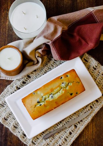 A top view shot of a freshly baked blueberry cake and candles in glasses as a decorati