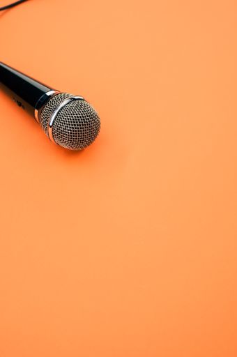A vertical shot of a microphone on an orange surface