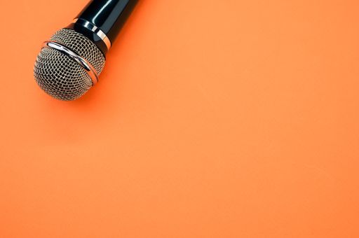 A high angle shot of a microphone on an orange surface
