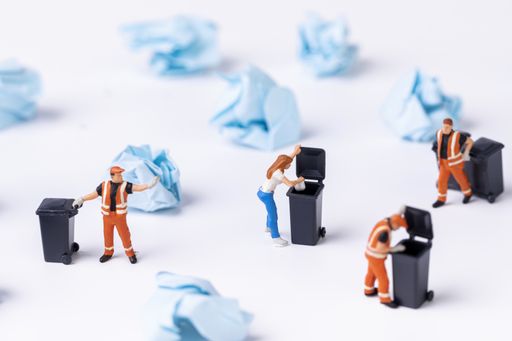 A selective focus shot of used paper and waste collector toys on a white background