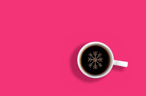 A top view of a cup of coffee with snowflake shaped foam on its surface