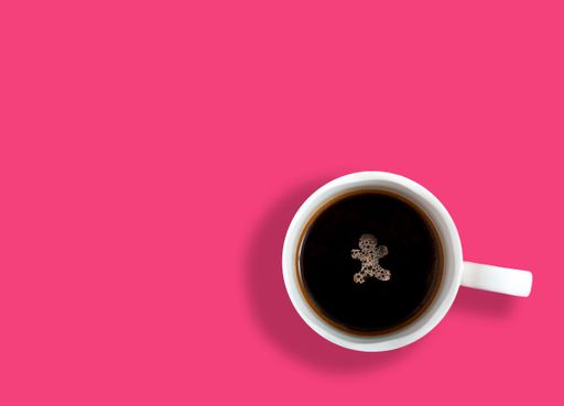 A top view of a cup of coffee with a Christmas gingerbread form foam on its surface