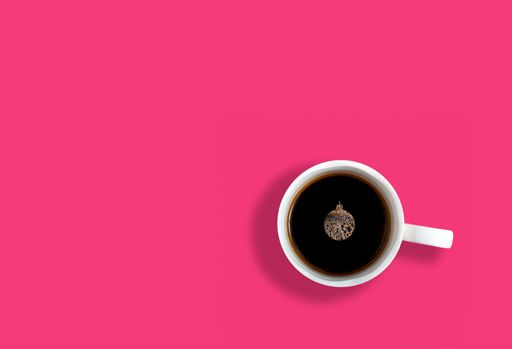 A top view of a cup of coffee with a Christmas ornament formed foam on its surface