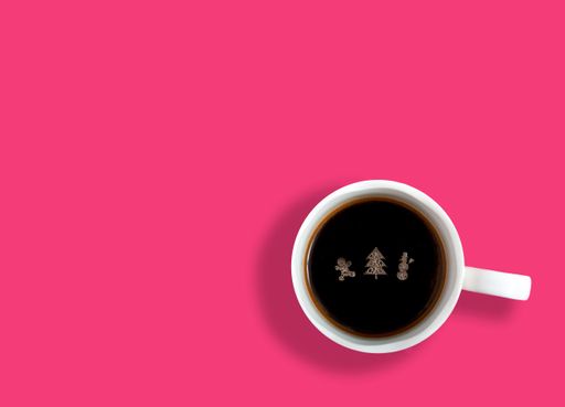 A top view of cup of coffee with Christmas tree, snowman and gingerbread shaped foam on its surface